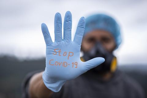 Sanitario pinta en sus guantes "Stop COVID-19"